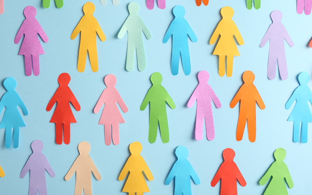 Cut out paper people in various colours representing diverse group of people on light blue background.